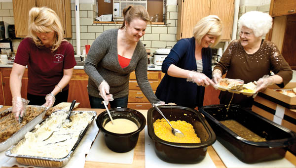 Amy Barnes, Laura Kettle, Michael Gleichauf and Joann Kincaid on Saturday serve the turkey dinners during a free Thanksgiving meal event at the First Baptist Church of Ironton.