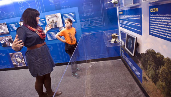Emily Roush with the Highlands Museum and Discovery Center talks to a young visitor in the newly constructed space and science center.