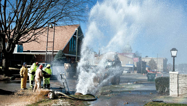 Water gushes as crews work to repair a burst water line on the corner of South Fifth and Washington streets in downtown Ironton.