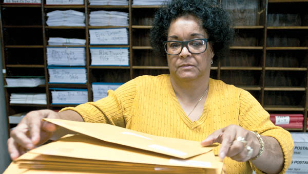 Cynthia Marshall organizes envelops as she and other members in the Lawrence County Treasurer’s Office prepare for first half taxes.