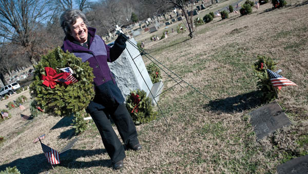 Juanita Southers, Wreaths organizer, removes wreaths from the graves at the soldiers plot at Woodland Cemetery