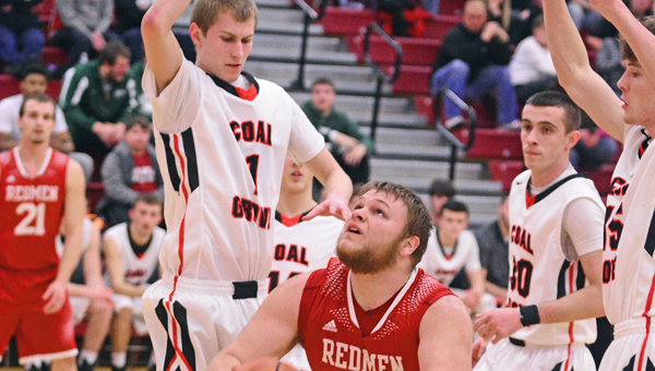 Coal Grove Hornets’ Travis Carey (1) and Brandon Adkins (right) surround Rock Hill Redmen center Austin Barcus during Wednesday’s Division III sectional tournament semifinal game. Coal Grove rallied to win 52-46. (Kent Sanborn of Southern Ohio Sports Photos)
