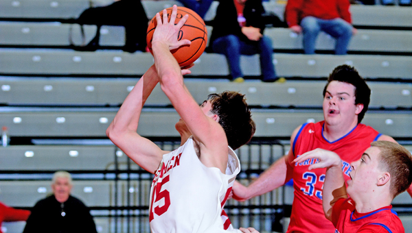 Rock Hill Redmen senior Austin Collins (15) takes a shot despite being tripped on his drive to the basket. Collins scored 20 points but the Redmen lost to Portsmouth 66-46 Saturday. (Kent Sanborn of Southern Ohio Sports Photos)