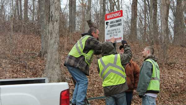 Larry Coleman from the Lawrence Scioto County Solid Waste Management District and community service workers put new signs up in the Wayne National Forest on Friday.