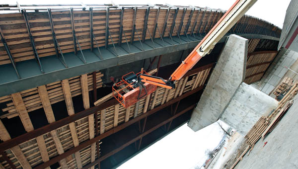 Employees from Brayman Construction Corp. remove planks from underneath finished bridge construction on Tuesday in Ironton.