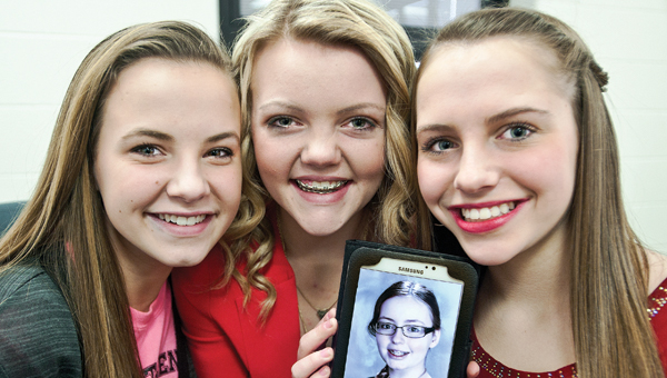 Fairland Middle School students Kelsie Warnock, Emma Conwell and Olivia Roberts, pictured left to right, hold a photo of their friend. Candy passed away from cancer back in July. Today the girls and their fellow students will present a check for $2,000 in honor of Candy to Hospice of Huntington.