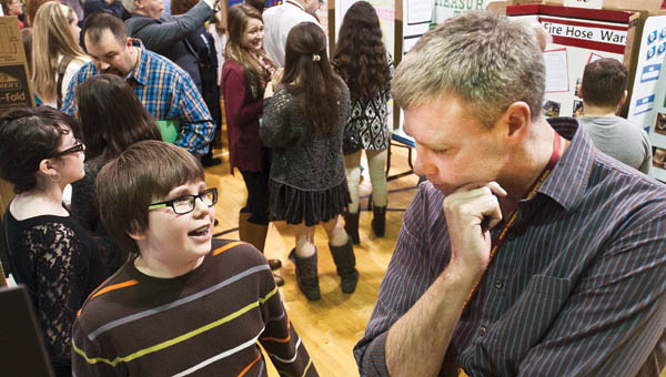 South Point school student Sean Hackney discusses his project “Under Siege” to judge Patrick Leighty during the 2015 Lawrence County Science Fair.