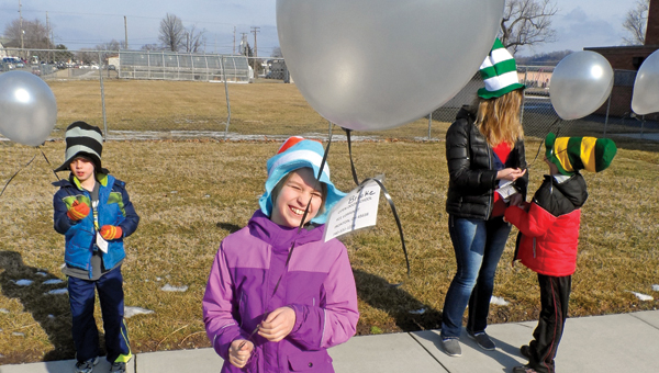 Brooke Ridenour, center, with William McComas, left, and aide Rachel Petitt and David Cooper, right, hold onto their balloons before the launch this past Monday.