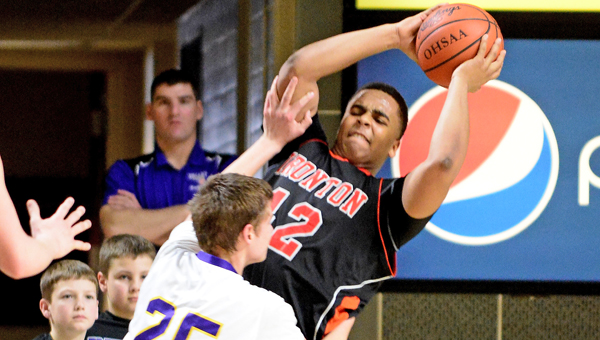 Ironton Fighting Tigers’ center Desmond Young (42) grabs one of his 11 rebounds while avoiding Lucasville Valley’s Aaron Linne (25) Ironton upset Valley 48-39 Sunday to reach the Division III district finals at 6 p.m. on Saturday. (Kent Sanborn of Southern Ohio Sports Photos)