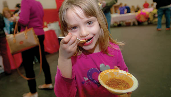 Six-year-old Abby Cox, of Greenup, enjoys her chili as she and her family make the rounds during the Chili Fest and Craft Show for DD Awareness Saturday at Dawson-Bryant High School.