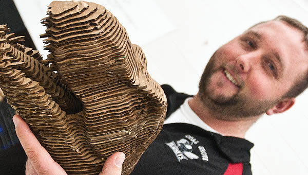 Tyler Waller shows off a 3D generated dinosaur created by students in his computer tech classes, using 3D laser equipment, at Dawson-Bryant High School.