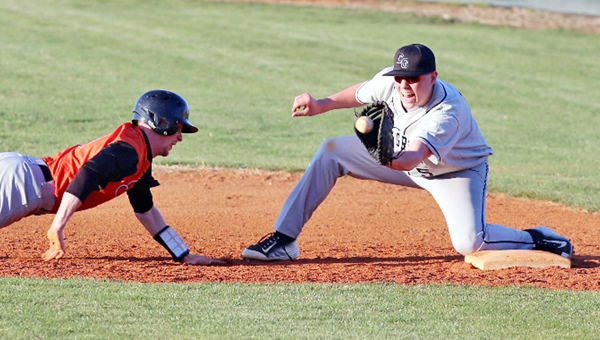 Coal Grove Hornets’ first baseman Jeb Jones (right) makes the catch on a pickoff throw attempt as he prepares to tag out a Raceland Rams’ baserunner. Coal Grove outlasted the Rams 16-15 on Wednesday. (Courtesy of Tim Gearhart of Tim’s News & Novelties of Ironton)