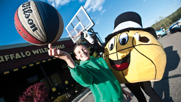 J.C. Damron and the Gus Macker mascot ham it up while shooting free throws during a promotional event Thursday at Buffalo Wild Wings.