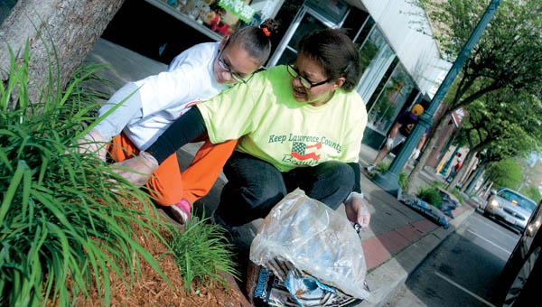 Ayanni Estes, left, and Carol Seward, right, represent the Ohio Association of Youth Clubs as they volunteer Saturday morning in downtown Ironton during the Great American Clean Up.
