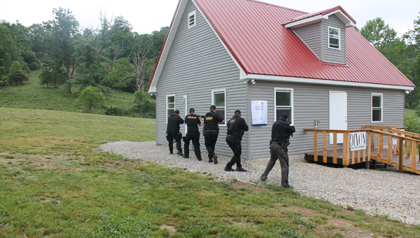 Members of the Lawrence County SWAT team get ready to arrest a gunman during a simulation Thursday at the dedication of the public safety training facility at Collins Career Center.