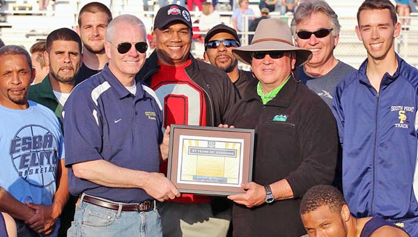 South Point High School’s annual invitational track meet took time to honor former Pointers’ head track coach Randy Smith with a plaque for his 37 years of service. Smith is surrounded by many of his former players as he accepts the plaque presented to him by South Point superintendent Mark Christian. (Courtesy of Tim Gearhart of Tim’s News & Novelties of Ironton)