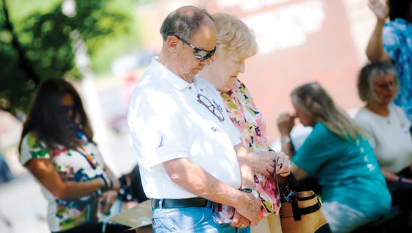 Ralph and Margy Kelley bow their heads in prayer Thursday afternoon, in front of the Lawrence County Courthouse.