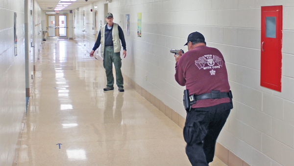 Sgt. Steve Cartmell of the Lawrence County Sheriff’s Office gets practice in hunting down a school shooter in front of Tactical Defense Institute (TDI) instructor Chris Wallace at Rock Hill Schools Thursday morning during a TDI training session with Rock Hill teachers and local law enforcement officers.