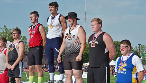Coal Grove’s Austen Pleasants (second from right) displays his medal for a fifth place in the Division III discus event as he stands on the awards’ podium. (Jimmy Walker/The Ironton Tribune)