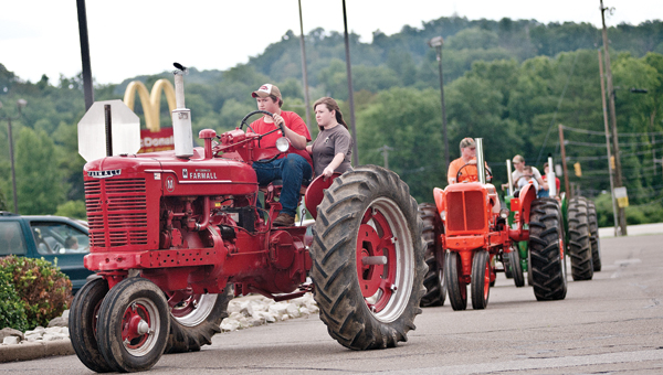Participants of Ironmasters Days take their tractors for a ride through the parking lot of the Ironton Hills Shopping Plaza for a parade on Saturday.
