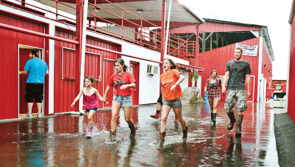 People make their way through extra large water puddles following a second storm to hit the Lawrence County Fairgrounds.