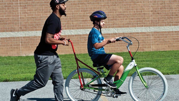 Christopher Alston, Jr. works with Christopher Norweck, of Barboursville, West Virginia, during the Lose the Training Wheels event at Huntington High School.