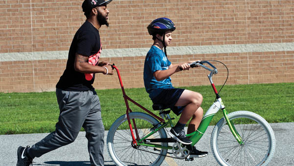 Christopher Alston, Jr. works with Christopher Norweck, of Barboursville, West Virginia, during the Lose the Training Wheels event at Huntington High School.