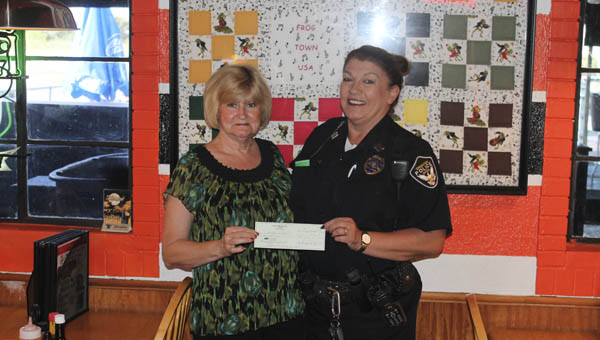 Frogtown owner Darlene Rutledge give a donation check to Captain Pam Wagner of the Ironton Police Department for the Fraternal Order of Police.