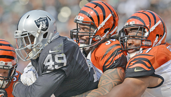 The Oakland Raiders' Jamize Olawale (49) is tackled by the Cincinnati Bengals' Rey Maualuga (58) and Vincent Rey (57) in the third quarter at O.co Coliseum in Oakland, Calif., on Sunday The Bengals won 33-13. (MCT Direct Photos)