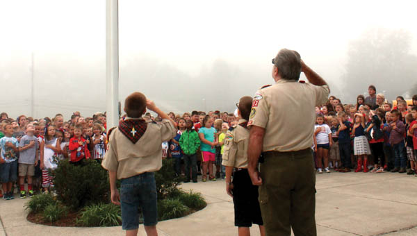Dawson-Bryant Elementary students and Boy Scouts Landon Davis and Tyler Nutter salute the flag after lowering it at the school’s Patriot Day ceremony Friday morning.