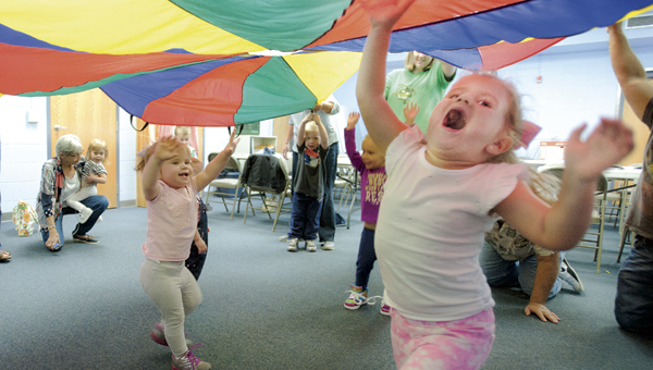 Sisters Lily, left, and Olivia Dalton, right, enjoys the parachute game during Toddler Time at the Briggs Lawrence County Public Library Ironton Branch Tuesday.