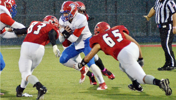 Rock Hill Redmen defenders Tanner Delong (83) and Brian French (65) close in to make the stop on Portsmouth Trojans’ quarterback Cole Lowery during Friday’s Ohio Valley Conference game. The Redmen used a strong ground game to beat the Trojans 38-14. (Robert S. Stevens & The Gold Studio of Ironton)