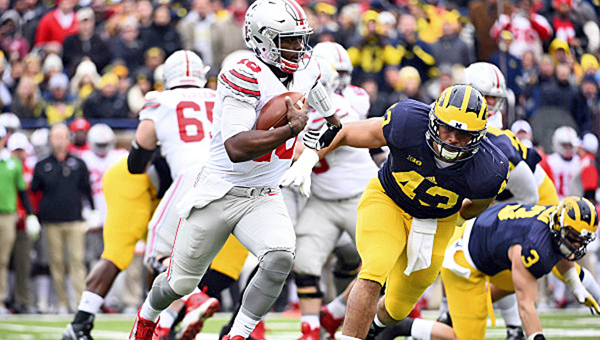 Ohio State Buckeyes’ quarterback J.T. Barrett (16) outruns Michigan Wolverines defensive end Chris Wormley (43) to gain yardage during the first quarter of Saturday’s game. Ohio State won 42-13. (Tim Fuller of USA TODAY/Courtesy Ohio State Athletics.com)