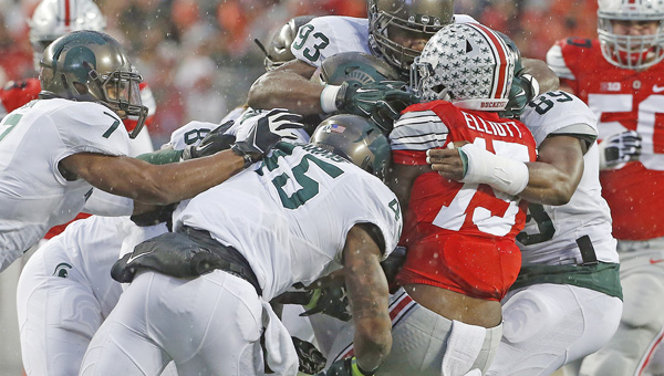 Ohio State running back Ezekiel Elliott (15) is tackled by a host of Michigan State Spartans in the first half last Saturday at Ohio Stadium in Columbus. Michigan State won, 17-14. The Buckeyes visit rival Michigan this Saturday. (Brooke LaValley/Columbus Dispatch/TNS.MCT Direct Photo)