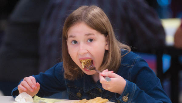 Twelve-year-old Emma Randan, of Proctorville, takes a mouthful of pancakes while at the annual Chesapeake-Proctorville Lions Club pancake breakfast on Saturday.