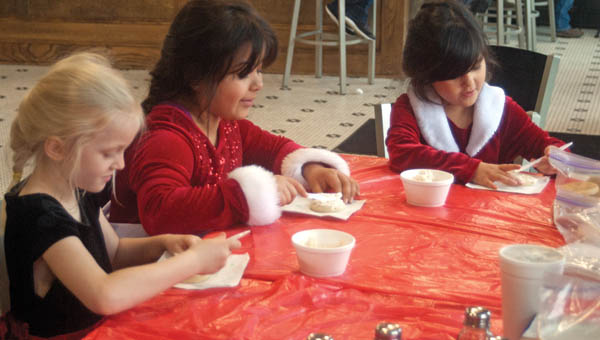 Rachel Minard, Brianna Lopez and Ariana Lopez decorate cookies at the Transit Café as part of the activities for children at Small Business Saturday.