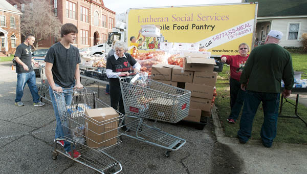 Volunteers gathered on Center Street next to St. Paul Lutheran Church to help with Christmas with Dignity on Saturday in Ironton.