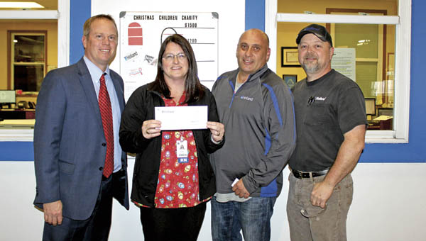 David Sheils, president of the St. Mary’s Foundation, and Anne Hammack, clinical manager of the St. Mary’s Breast Center, receive a check from Holland’s Miguel Celdran, plant manager, and Terry Lucas, strap department manager.