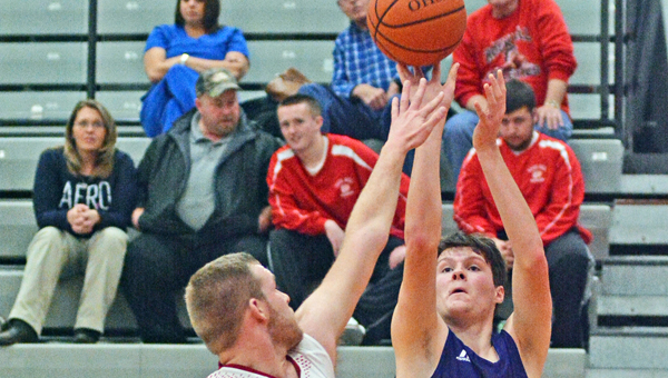 St. Joseph Flyers’ Zac McGraw (21) takes a baseline jumper over the outstretched hand of the Rock Hill Redmen’s Alex Nance during Tuesday’s game. St. Joseph won 69-57. (Robert S. Stevens & The Gold Studio of Ironton)