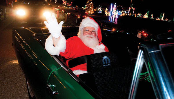 Santa Claus makes an appearance at the Coal Grove Christmas Parade riding in a Plymouth convertible Friday evening.
