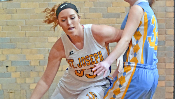 St. Joseph Female Flyers’ Megan Riley (left) drives the baseline past an Ohio Valley Christian defender during Monday’s game. The Female Flyers breezed past the Lady Defenders 65-19. (Kent Sanborn of Southern Ohio Sports Photos)