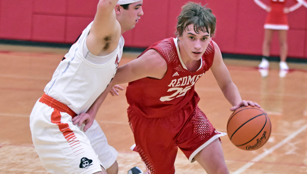 Rock Hill Redmen’s Mason Darby (25) drives toward the basket against a Wheelersburg defender. Darby had 24 points but the Redmen lost in the Division III sectional tournament. (Kent Sanborn of Southern Ohio Sports Photos)