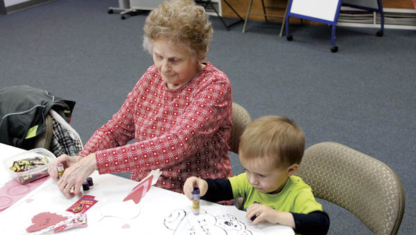 Reed Craft, 2, and his grandma work on Valentine’s Day crafts during Ironton Briggs Library toddler time Tuesday morning.