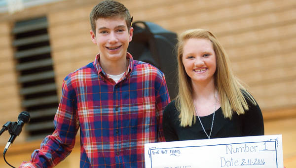 Students Brady Floyd, left, and Raiden Jenkins, right, present a check for $1,000 to the Junior Diabetes Research Foundation.