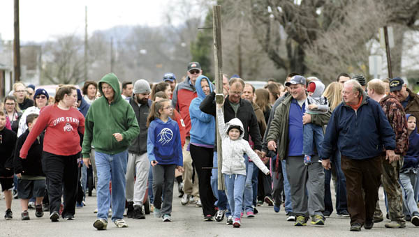 Members of Sharon Baptist Church make their annual pilgrimage down South Fourth Street to Woodland Cemetery carrying a wooden cross on Good Friday.