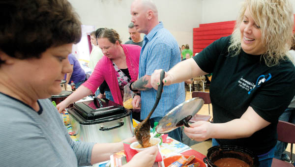Megan Chaffin, with Community Home Health Care, serves homemade chili during the annual Chili Fest and Craft Show for DD Awareness Saturday at Dawson-Bryant High School.