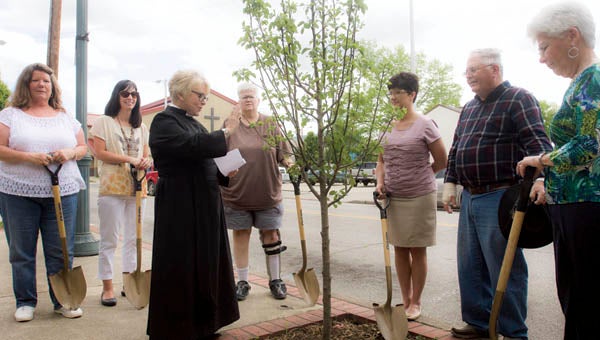 The Rev. Sally Schisler performs a tree blessing in honor of Arbor Day in downtown Ironton with members of Ironton in Bloom.