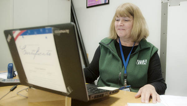 Kathy Moore, site coordinator for VITA, reviews tax documents Tuesday at the Ohio Means Jobs in Ironton.