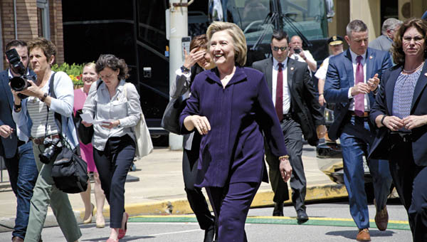 Democratic presidential candidate Hillary Clinton walks up 15th Street in Ashland to meet with supporters prior to her roundtable discussion on jobs at Alma’s Italian Restaurant on Monday.