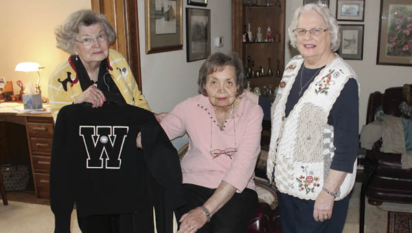 Anna Lou Coburn Robinson, left, holds her Waterloo Wonders cheerleading uniform at the home of Georgia Hairston Triplett, a former cheerleader and sister of Wonders coach Magellan Hairston, center. Robinson donated the uniform to the Lawrence County Museum and presented it to trustee Kay Rader, right.